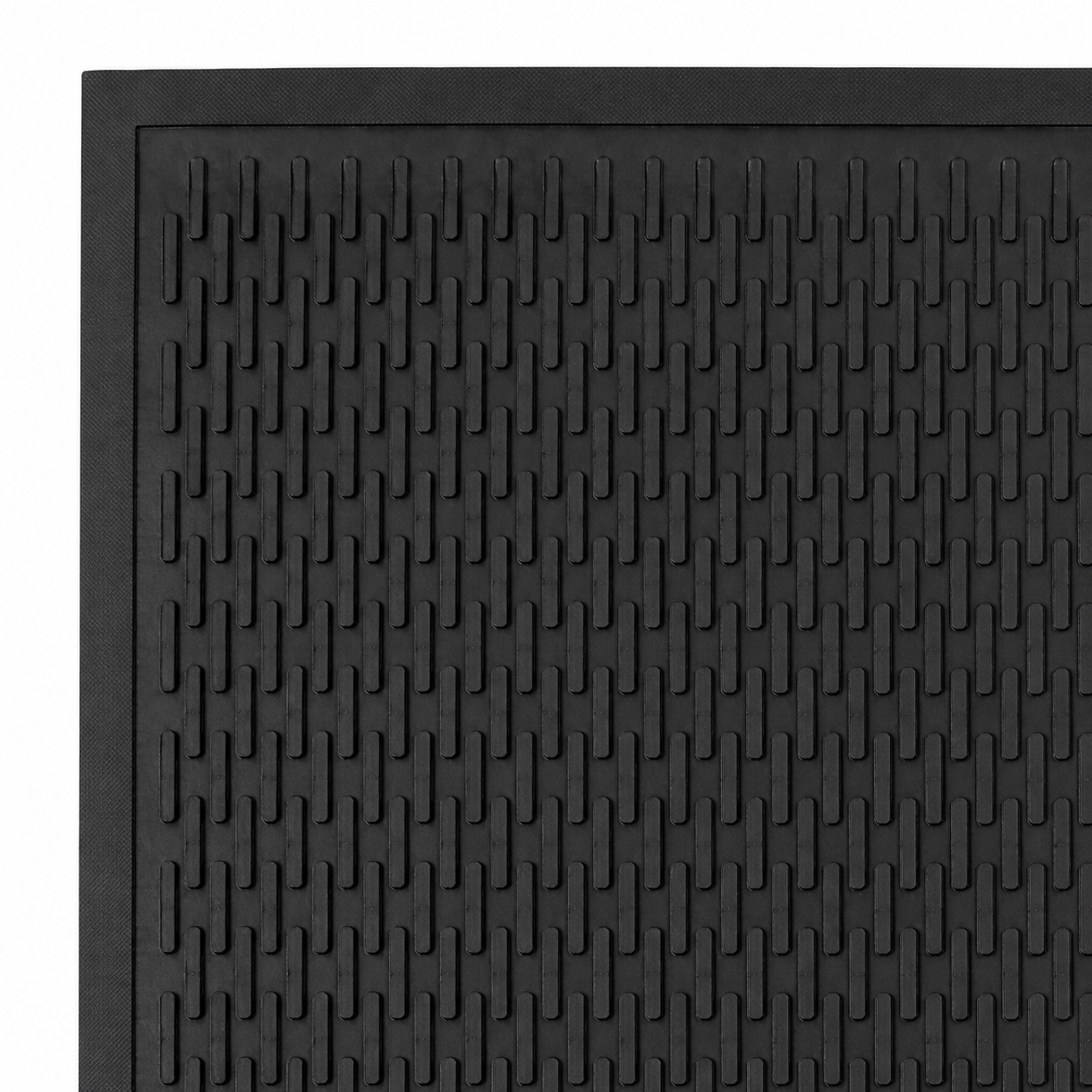 Close-up of the raised scraper surface on a black rubber entrance mat